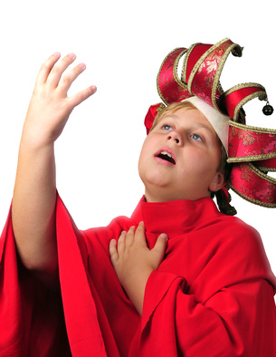A child wearing a red costume and an ornate hat poses with one hand raised and the other on their chest, appearing to perform dramatically.