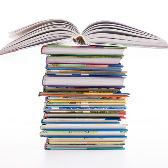 A stack of colorful hardcover books with an open book placed on top, all set against a white background.