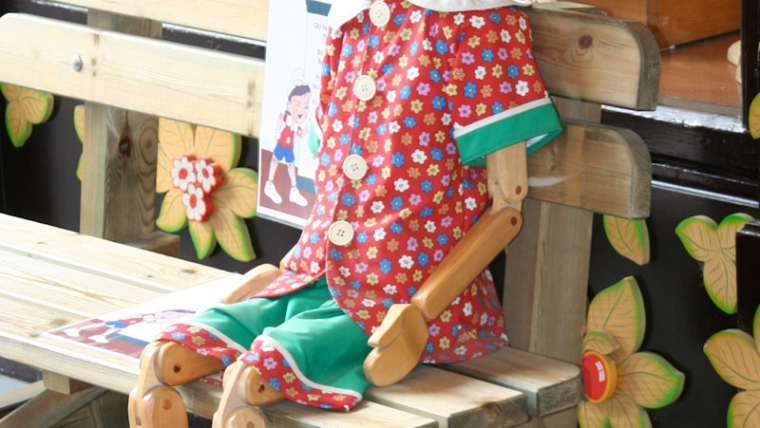 Pinocchio statue on wooden bench